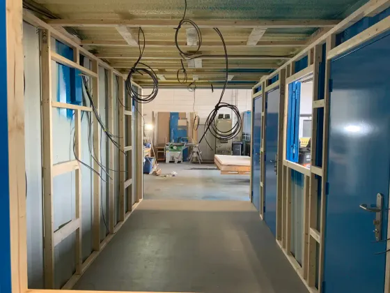Internal timber framing and first-fix electrical cabling inside a shipping container conversion under construction